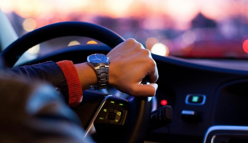 man driving a car wearing wrist watch